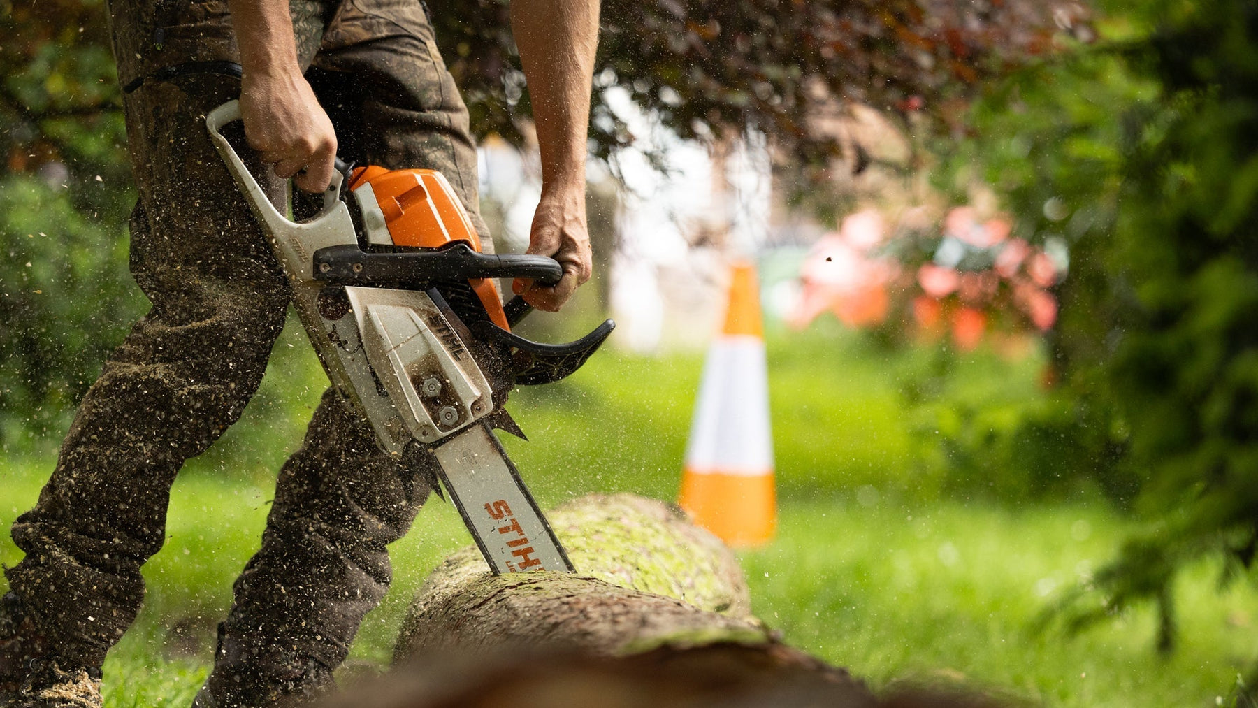 Man using a Stihl Chainsaw cutting into a log