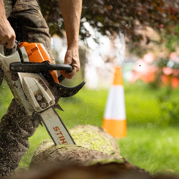 Man using a Stihl Chainsaw cutting into a log